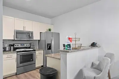 a kitchen with stainless steel appliances and white cabinets at Modern 3 Bed Villa Newly Renovated Prime Location in Kissimmee