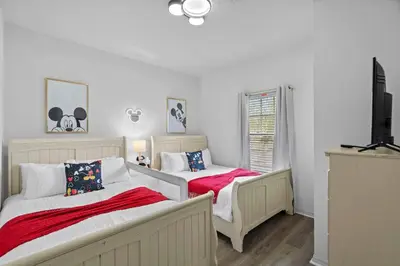a bedroom with two beds and a flat screen tv at Modern 3 Bed Villa Newly Renovated Prime Location in Kissimmee