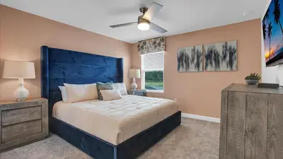 a bedroom with a large bed with a blue headboard at Sierra Sky in Kissimmee