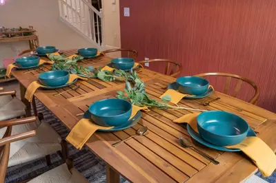a wooden table with blue bowls and plates on it at 5BD - Movie Room, Pool, BBQ - Near Disney World in Kissimmee