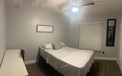 a small bedroom with a bed and a window at Cozy Haven with Premier Privacy 4 bedroom in Orlando