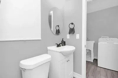 a white bathroom with a toilet and a sink at Modern Cuartito near Winter Park in Orlando