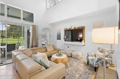 a living room with a couch and a tv at Lux 6BrVilla -Pool&ResortAmenities -10mins to Parks in Kissimmee