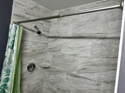 a bathroom with a shower with a stone wall at Tranquile Vacation Home near Universal studio in Orlando