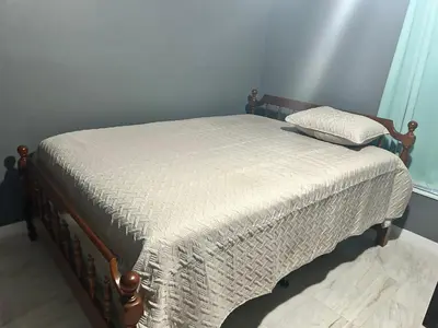 a bed with a white comforter and a pillow on it at Tranquile Vacation Home near Universal studio in Orlando