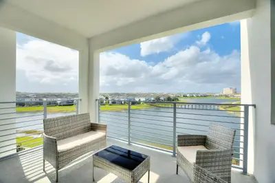 a balcony with two chairs and a view of the water at Storey Lake Resort 2bd Condo Overlooking Water #840 condo in Kissimmee