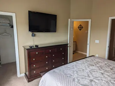 a bedroom with a dresser with a flat screen tv on the wall at La Dolce Vita Gated resort in Orlando