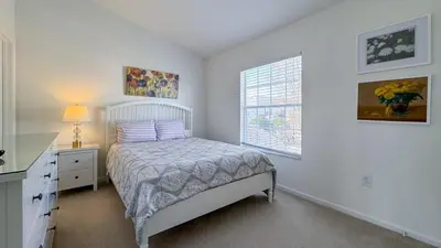 a bedroom with a bed and a desk and a window at Tequilla Sunrise at Windsor Hills in Orlando