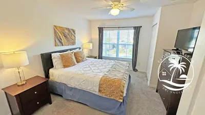 a bedroom with a bed and a flat screen tv at Villas Standard Seven Dwrafs Resort - Close to Disney in Kissimmee