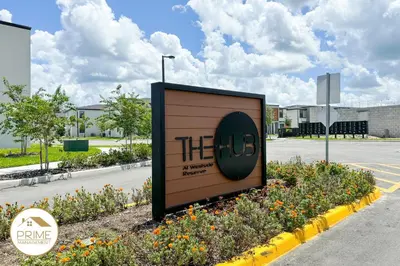 a sign in front of a parking lot with flowers at New 3BD3BA Townhouse Themed Near Disney in Kissimmee