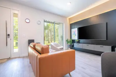 a living room with a couch and a flat screen tv at 3221 Brand New Family 3BD Townhouse near Disney in Kissimmee
