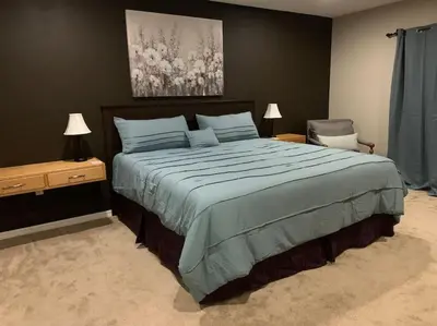 a bedroom with a large bed and a chair at Lakefront Home Where You Can Retreat and Relax in Orlando