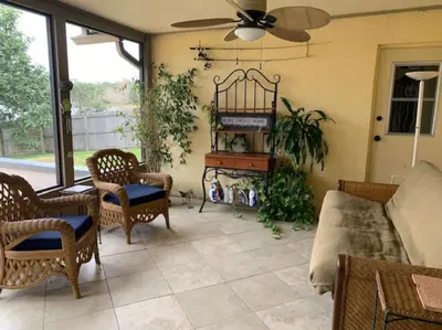 a living room with a couch and chairs and a fan at Lakefront Home Where You Can Retreat and Relax in Orlando