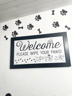 a welcome sign on a wall with paw prints at The Pink House of Celebration in Kissimmee