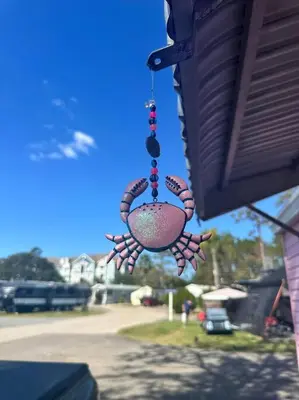 a chime hanging from the side of a house at The Pink House of Celebration in Kissimmee