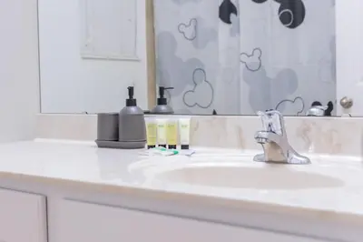 a bathroom counter with a sink and a mirror at Family 4br House w Pool near to Disney Much More in Kissimmee