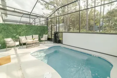 a swimming pool in a glass house with a patio at 5 Bedroom 5 Bathroom Paradiso Grande 10352 in Orlando