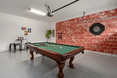a room with a pool table and a brick wall at Private Heated Pool Billiard lounge 6MI to Disney in Orlando