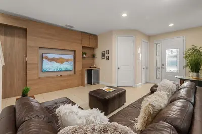 a living room with a couch and a tv at Private Heated Pool Billiard lounge 6MI to Disney in Orlando