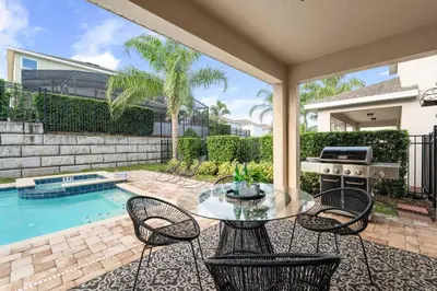 a patio with a table and chairs next to a pool at Private Heated Pool Billiard lounge 6MI to Disney in Orlando
