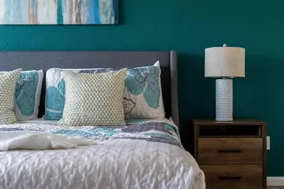a bed with pillows and a lamp on a night stand at Magical 6BR Family Retreat with Pool Near Disney in Orlando