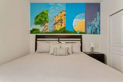 a bedroom with a white bed and a painting on the wall at Magical 6BR Family Retreat with Pool Near Disney in Orlando