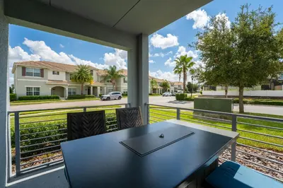 a table and chairs on a balcony with a view of a street at Themed 3-bed 2 bath condo at Storey Lake Resort in Kissimmee