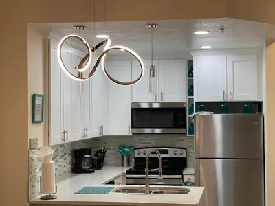 a kitchen with a stainless steel refrigerator and a chandelier at Venetian Bay Villages in Kissimmee