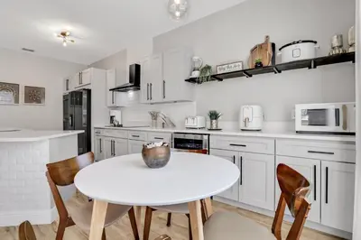 a kitchen with white cabinets and a table and chairs at Free Water Park Luxury Living in Orlando