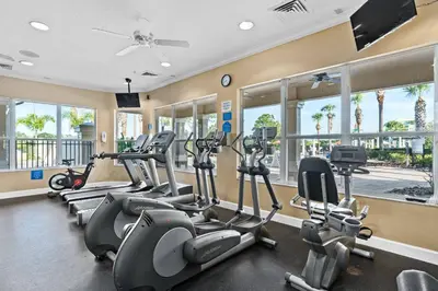 a gym with several treadmills and elliptical machines at Windsor Hills Water Park Adventure Home in Orlando