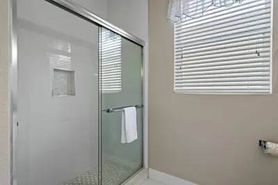 a shower with a glass door in a bathroom at 6BR Fun in the Sun with FREE water park in Orlando