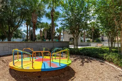 a colorful playground in a park with trees at Windsor Hills Condo: Water Park Included in Orlando