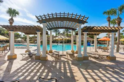 a pool with tables and chairs and a pavilion at Windsor Hills Condo: Water Park Included in Orlando