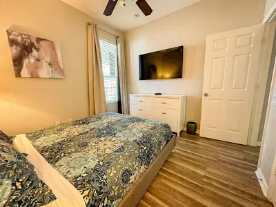 a bedroom with a bed and a dresser and a window at Family Fun 6BR Poolside w Water Park Game Room in Orlando