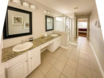 a bathroom with two sinks and a large mirror at Family Fun 6BR Poolside w Water Park Game Room in Orlando
