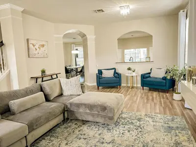 a living room with a couch and two blue chairs at Family Fun 6BR Poolside w Water Park Game Room in Orlando