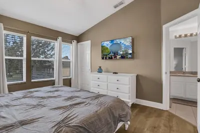 a bedroom with a bed and a dresser and windows at Water Park Haven: Spacious 3BR Windsor Hills in Orlando