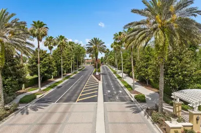 an empty street with palm trees on either side at Elegant Getaway Windsor Hills Condo w Water Park in Orlando