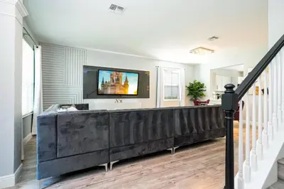 a living room with a large couch and a tv at FREE Water Park Fun Included Large Resort Home in Orlando