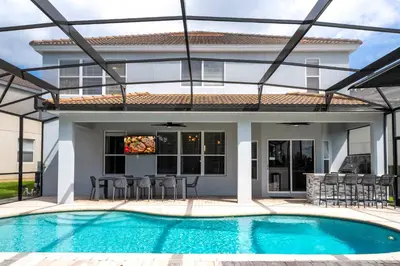 a villa with a swimming pool and a house at FREE Water Park Fun Included Large Resort Home in Orlando