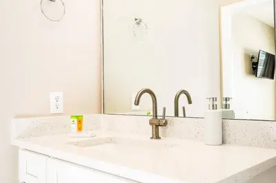 a white bathroom with a sink and a mirror at Family-Friendly Villa Resort: Free Water Park in Orlando