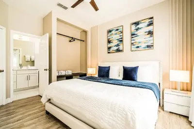 a bedroom with a large bed with blue pillows at Family-Friendly Villa Resort: Free Water Park in Orlando