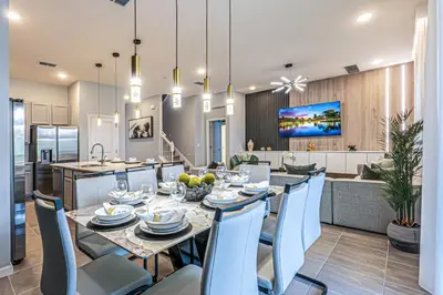 a dining room and kitchen with a table and chairs at Luxury Meets Adventure 8BR Condo with Themed Rooms in Orlando