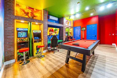 a room with a pool table and arcade games at NEW Spectacular Home Windsor Hills in Orlando