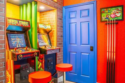 a room with a pinball machine and a blue door at NEW Spectacular Home Windsor Hills in Orlando