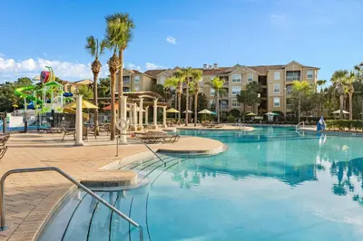 a swimming pool in a resort with a playground at Vacation Haven Windsor Hills Condo with Water Park in Orlando