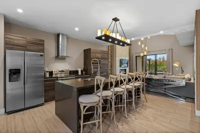 a kitchen with a island with bar stools at Elegant Escape: 4BR Villa near Disney Views in Orlando