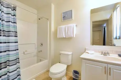 a bathroom with a toilet and a sink and a shower at Family Paradise 4BR Compass Bay Townhome Sleeps 11 in Kissimmee