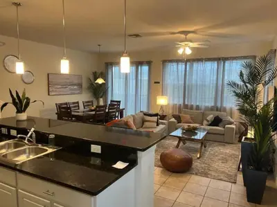 a kitchen and living room with a couch and a table at Family Paradise 4BR Compass Bay Townhome Sleeps 11 in Kissimmee