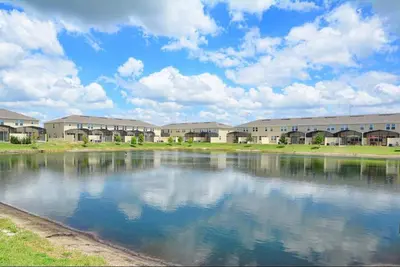 a large body of water in front of a building at Family Paradise 4BR Compass Bay Townhome Sleeps 11 in Kissimmee